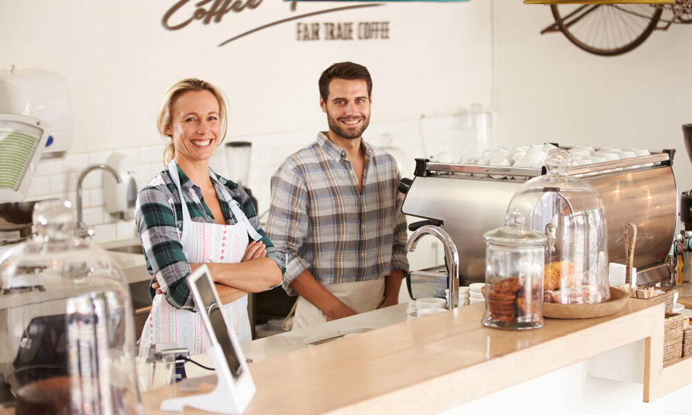 Smiling local café workers in a coffee shop